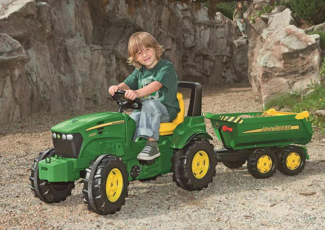 Niño jugando con su tractor de pedales John Deere 7930 y su remolque opcional