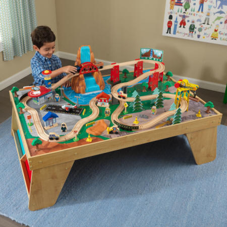 Niño con su kidkraft set de trenes con mesa estacion y cascada natural 18001
